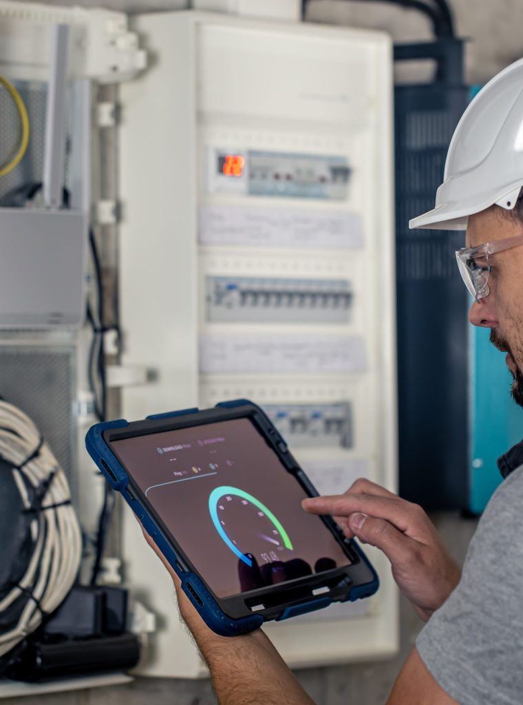 Man, an electrical technician working in a switchboard with fuses. Installation and connection of electrical equipment.