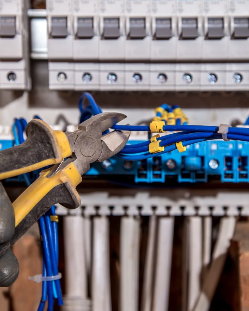 the Assembly of the electrical panel, electrician job, a robot with wires and circuit breakers